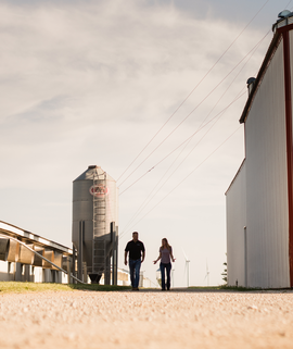 Pork-producer-walks -alongside-hog-barn